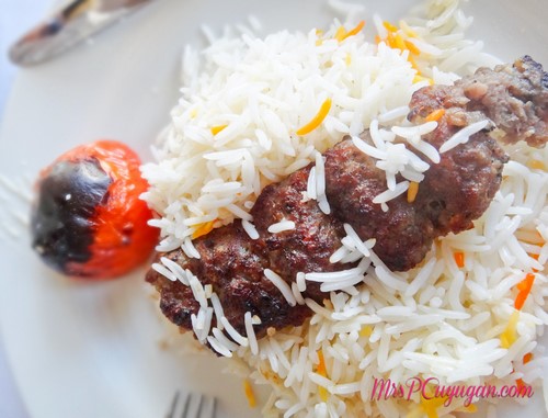 CHELOU KEBAB KUBIDEH Irans's national dish of 2 sticks of kebab kubideh charbroiled, topped with steamed lon grain rice sided with grilled tomatoes